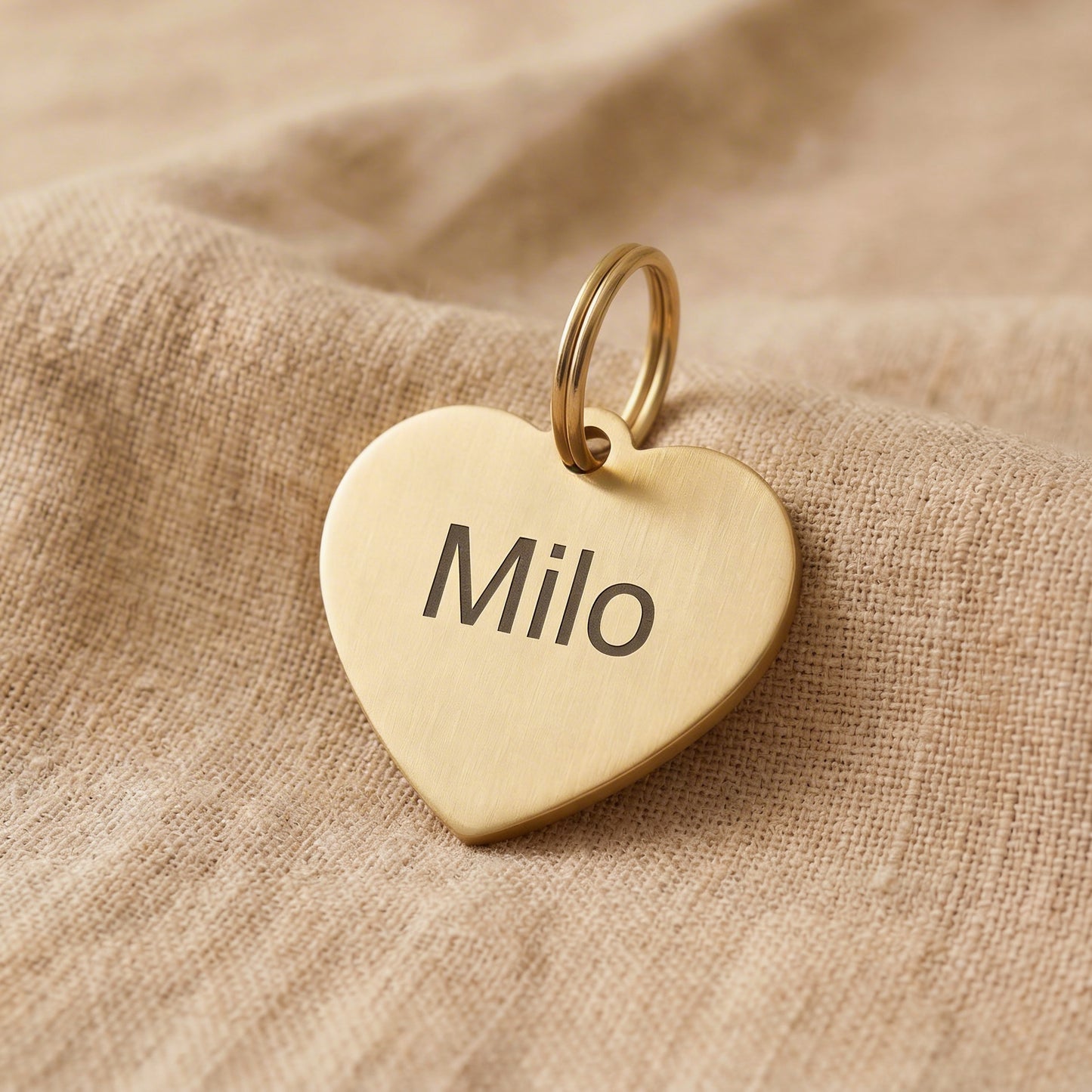 Herzförmiger Hundeanhänger aus goldfarbenem Metall mit Name Milo personalisiert